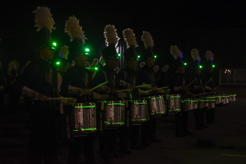 Snare drums in the dark with green lights on drums