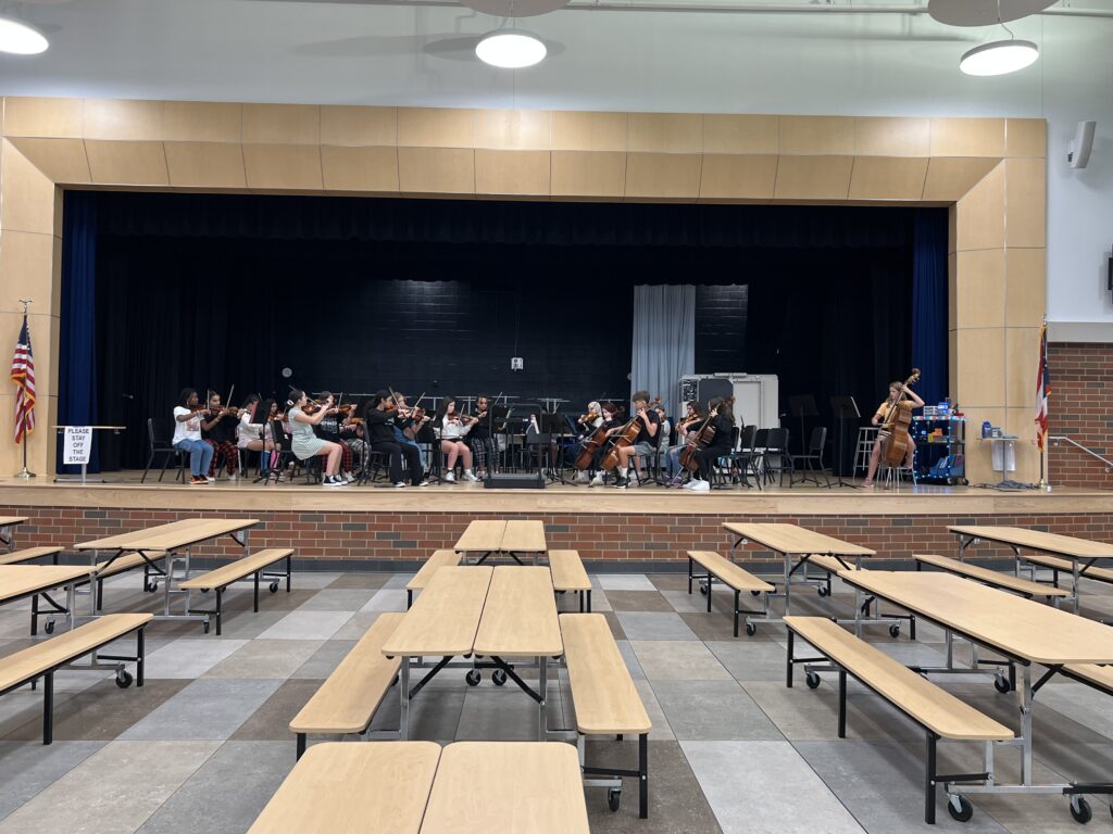 Students at Memorial rehearse on the stage before the 2024 Fall Concert.