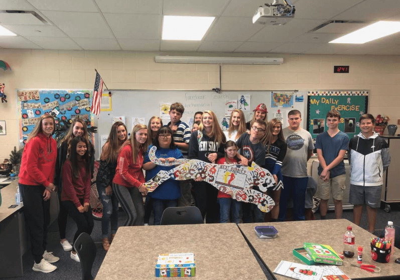 Students involved in Best Buddies pose with their jaguar cut out.