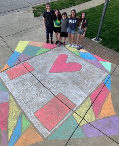 Kylee Queler (11) and Joey Lagana (12) have fun with sidewalk chalk after finishing eLearning for the day Photo by Kylee Queler (11).