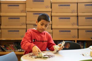 Darby Creek student counting money for fundraiser.