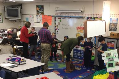 Visitors talking to students about the exhibits