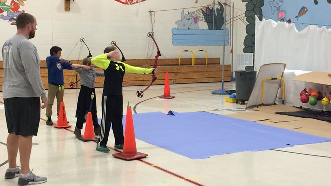 students shooting with bow and arrows