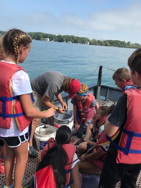 students on a boat checking water quality